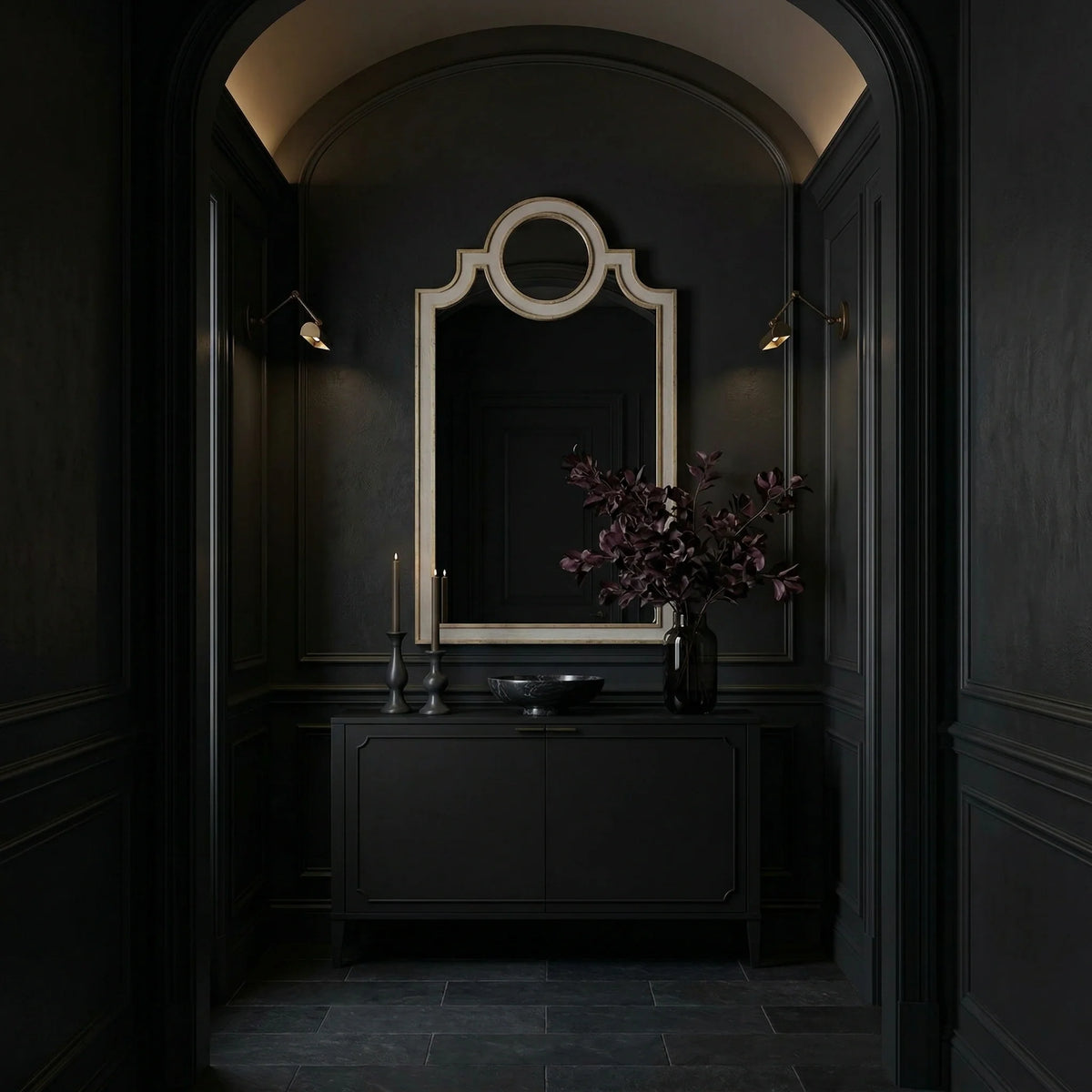 Ambella Home 26 Chateau Mirror in antique silver leaf, tall decorative wall mirror with a circular crest detail styled above a dark credenza in a moody luxury entryway