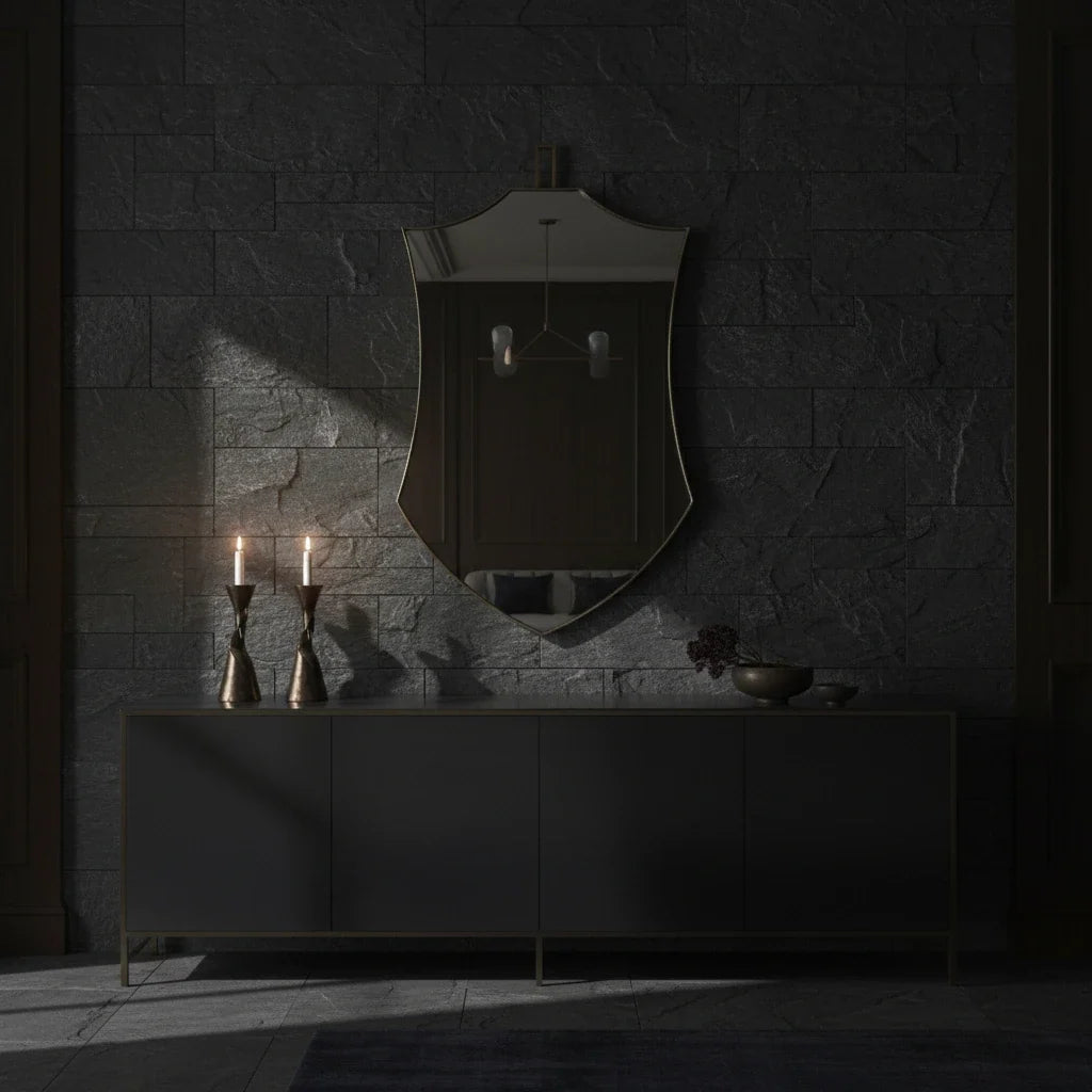 Dark interior with a mirror, candles, and a console table against a stone wall.