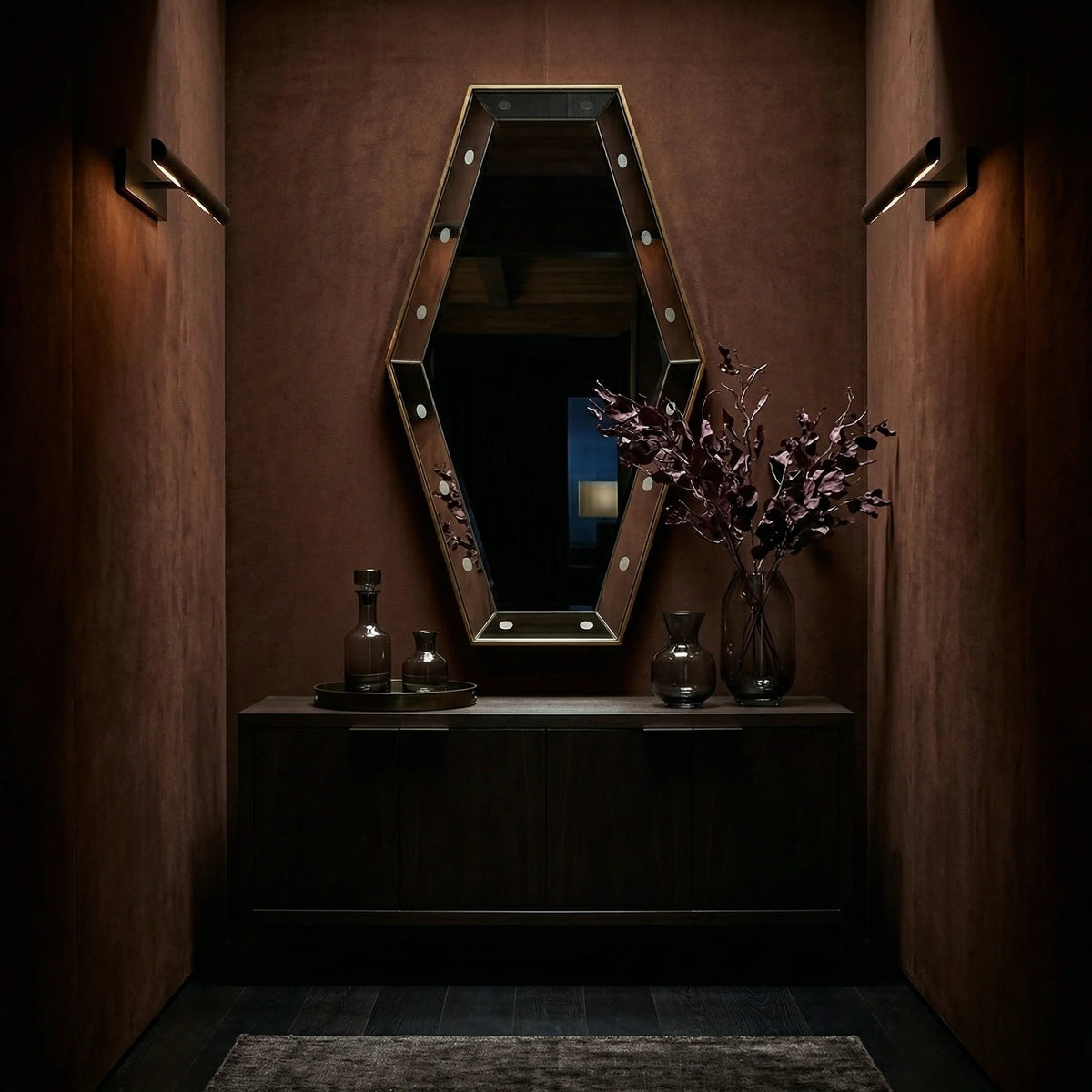 30 inch Key Hole Mirror by Ambella Home with antique gold trim and elongated faceted silhouette, styled above a dark console in a dramatic entry corridor