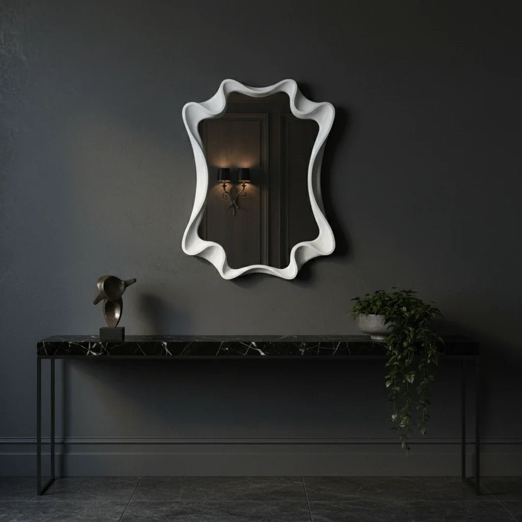 Decorative mirror with wavy frame on a dark wall above a console table.