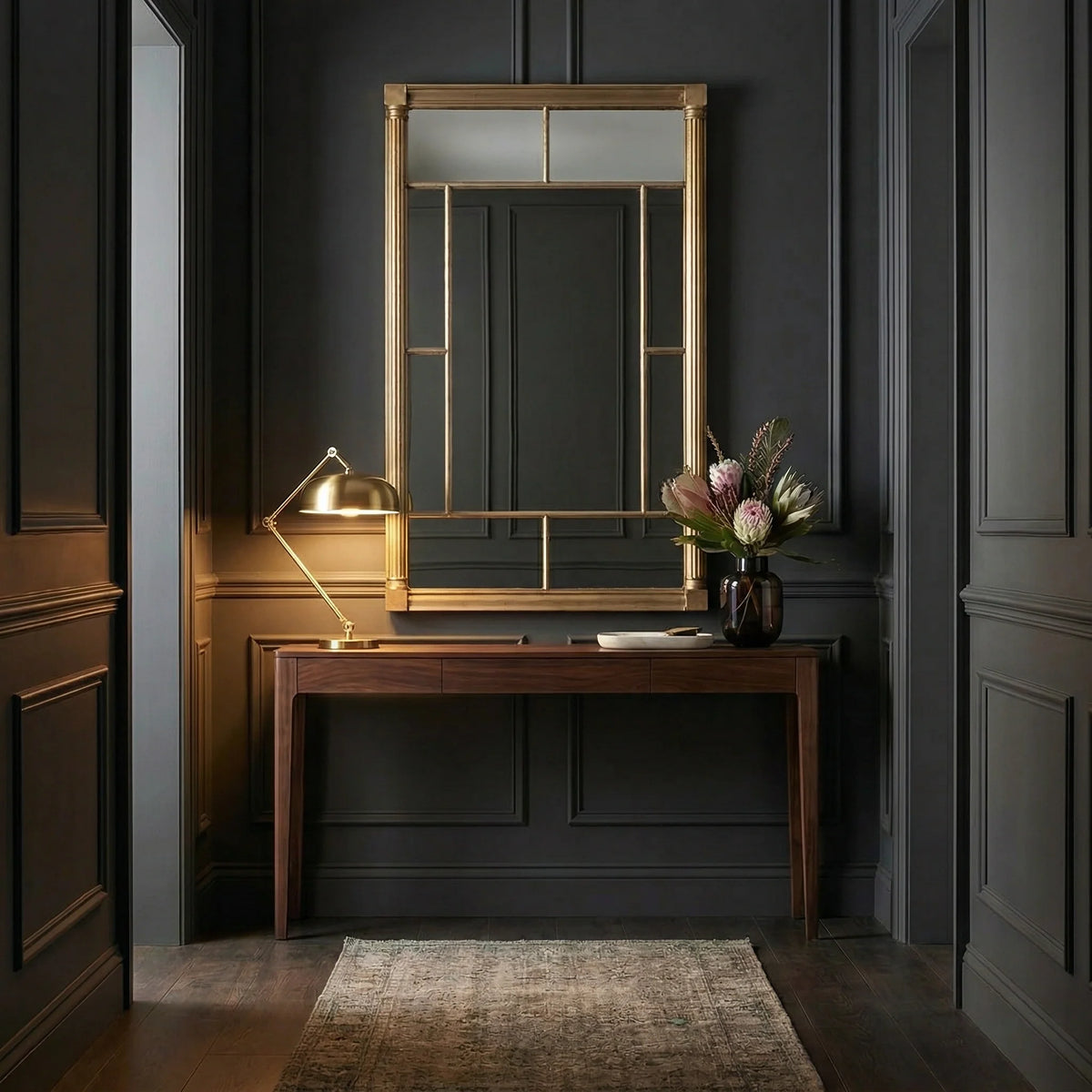 Ambella Home Rochelle Pier Mirror in vermeil above a slim console table, designed with fluted columns, antique mirror surround panels, and a clear glass center mirror