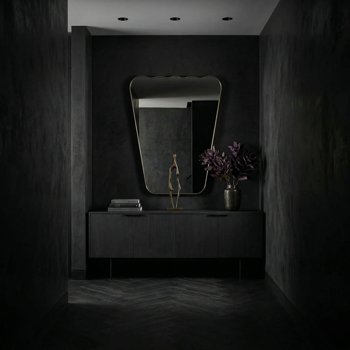 Antiqued brass 38 Wavy Mirror by Ambella Home styled in a modern dark entry hall above a minimalist credenza, featuring a fluid asymmetrical silhouette and softly curved top edge for luxe wall décor