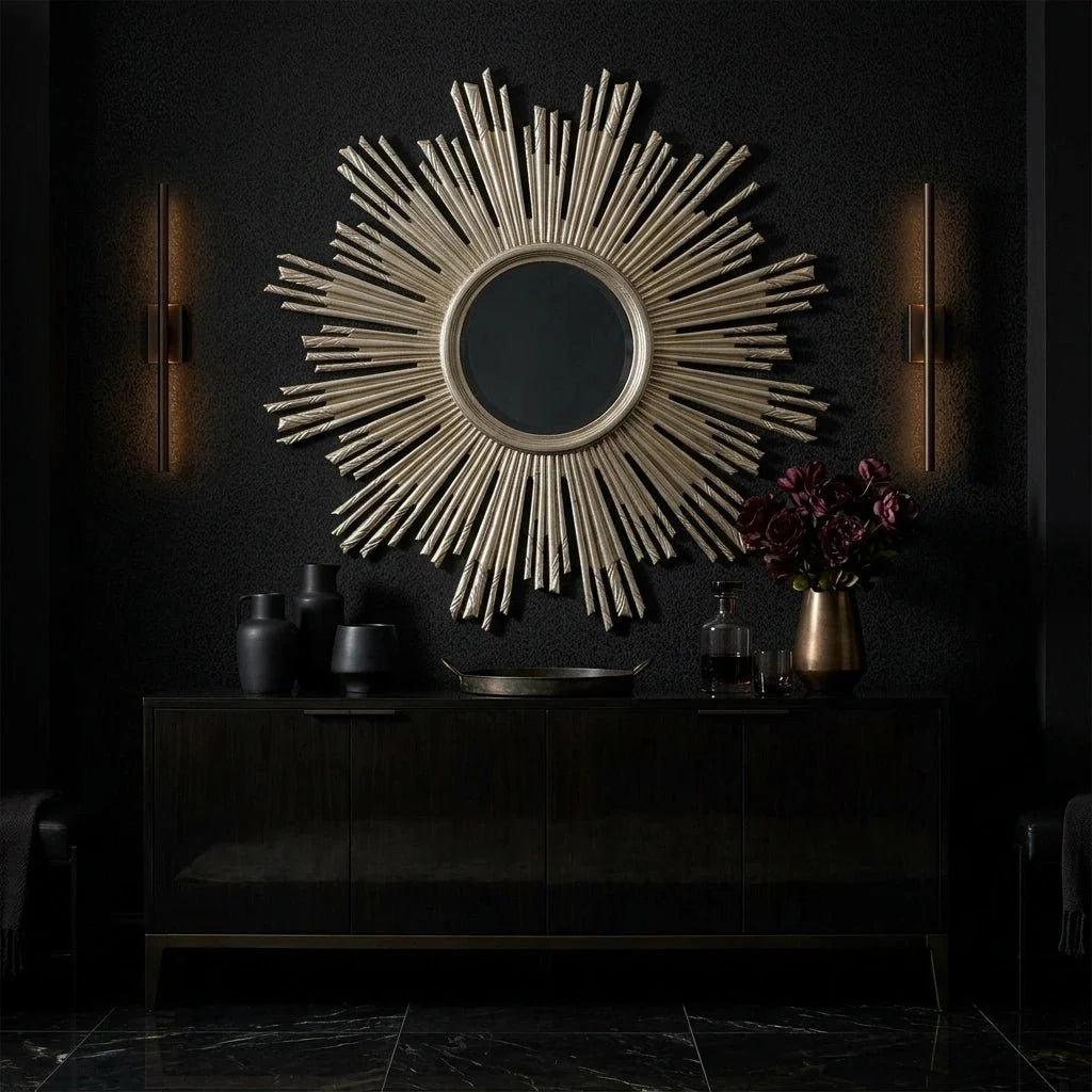 40 Apollo Mirror - Leafed Champagne by Ambella Home styled above a glossy black credenza in a dramatic luxury entryway, featuring a sculptural sunburst silhouette, round center mirror, and radiating leafed champagne rays against a deep charcoal wall