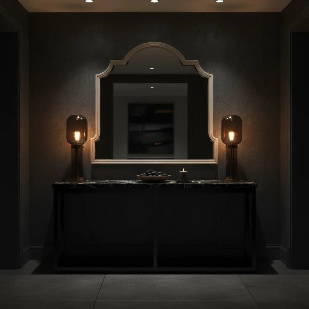 Dark interior with a mirror, table, and decorative items against a dark wall.