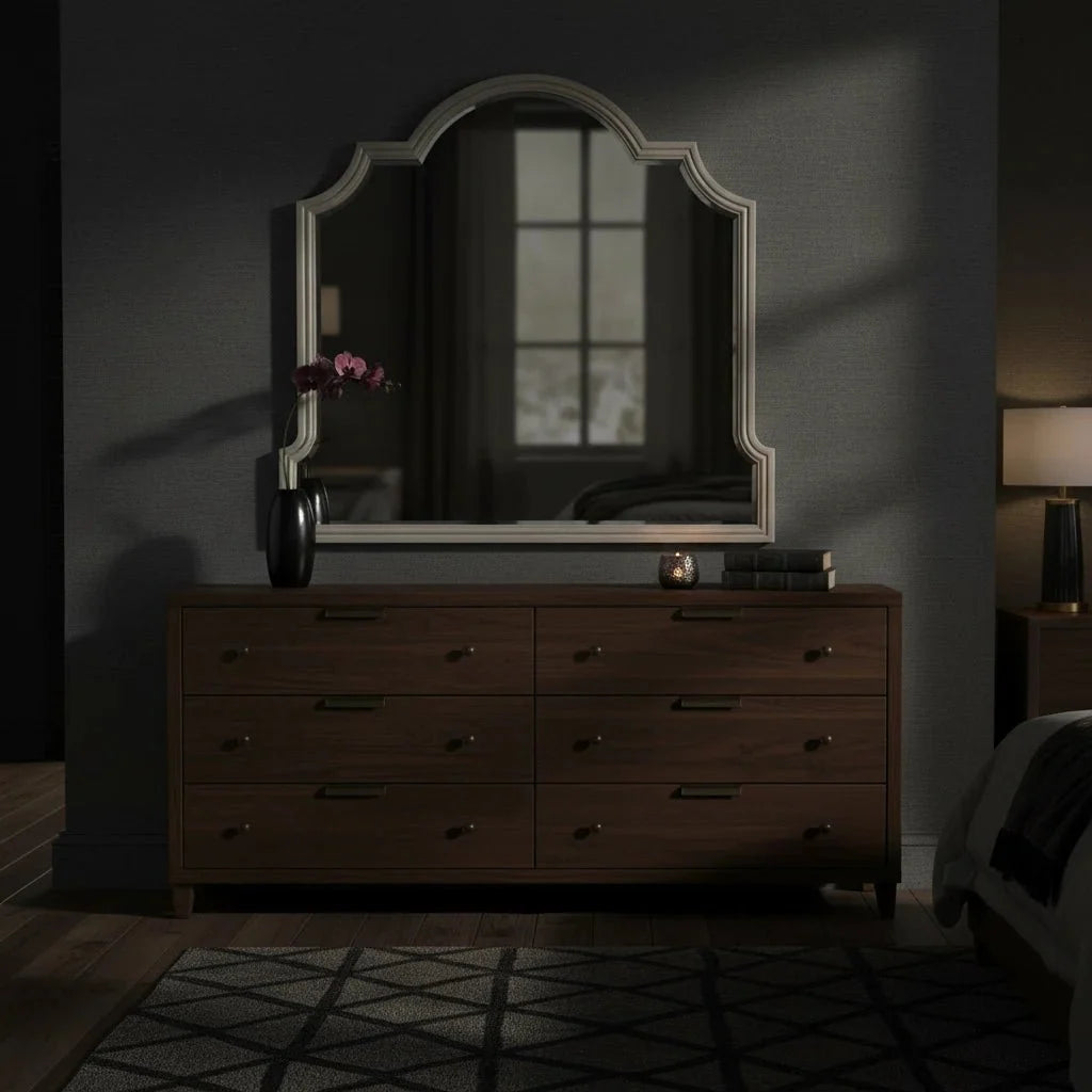 Wooden dresser with a large mirror in a dimly lit room