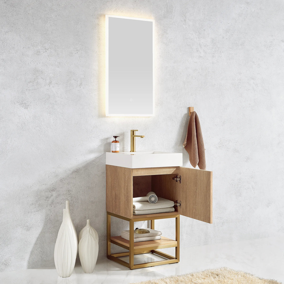Vanity with the door open and towels stored inside, lit mirror on the wall above