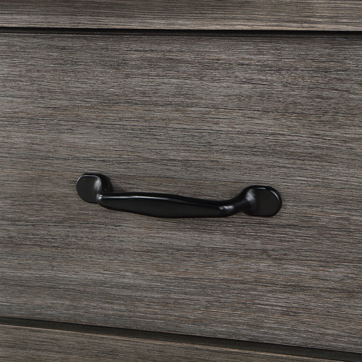 Rounded black drawer pull against grained Classical Grey wood