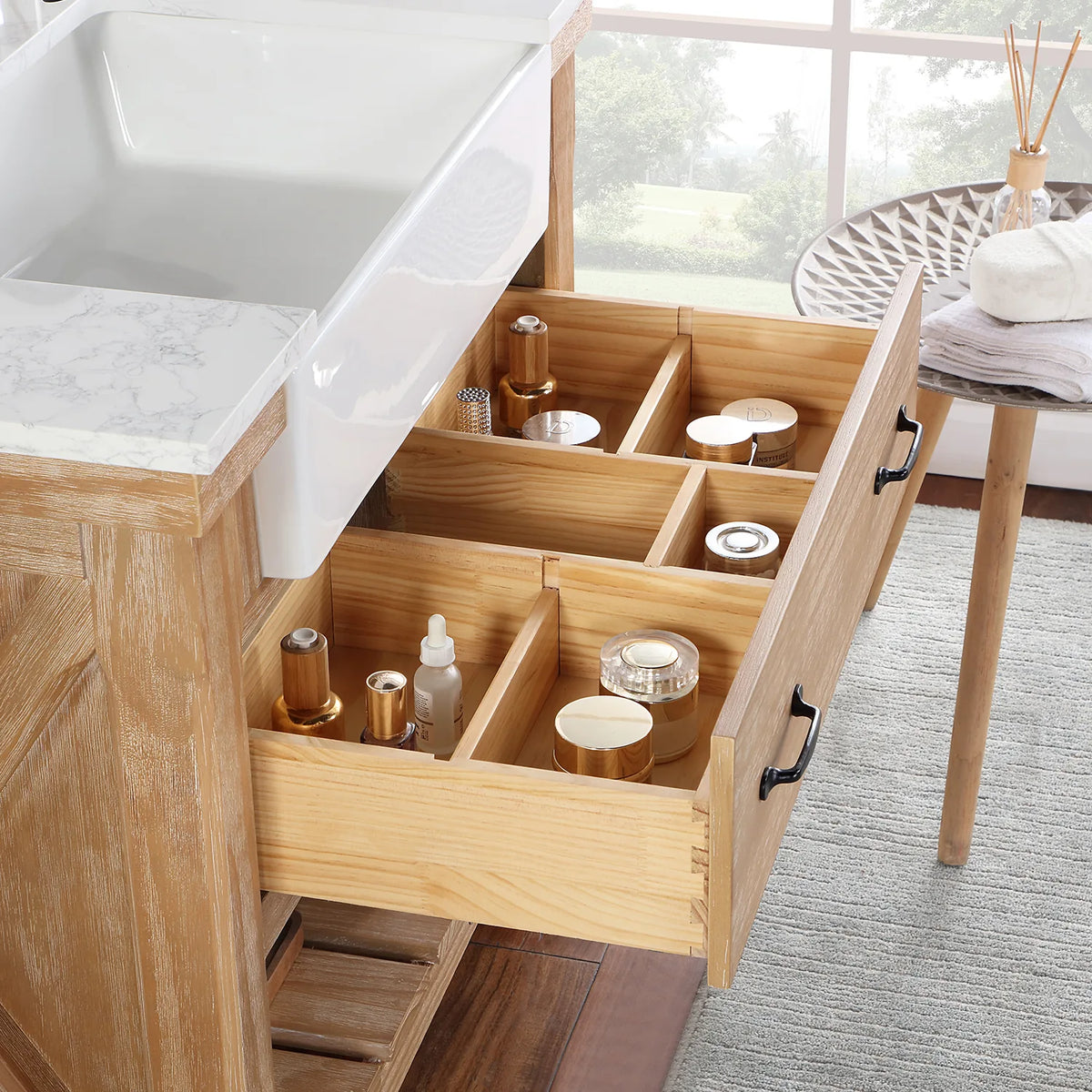 Pulled-forward drawer where jars, bottles and a hairbrush sit in divided compartments