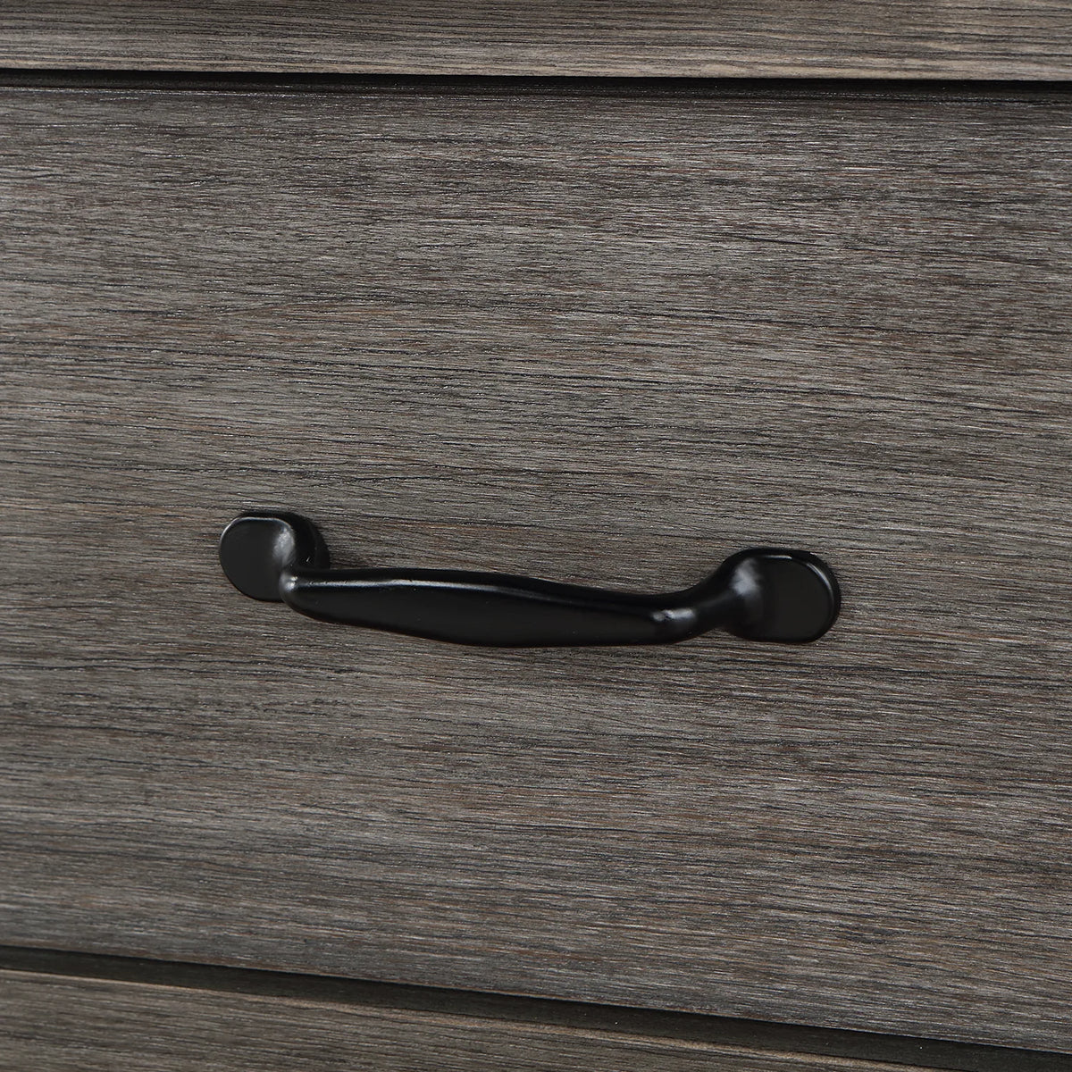 Rounded black drawer pull against grained Classical Grey wood