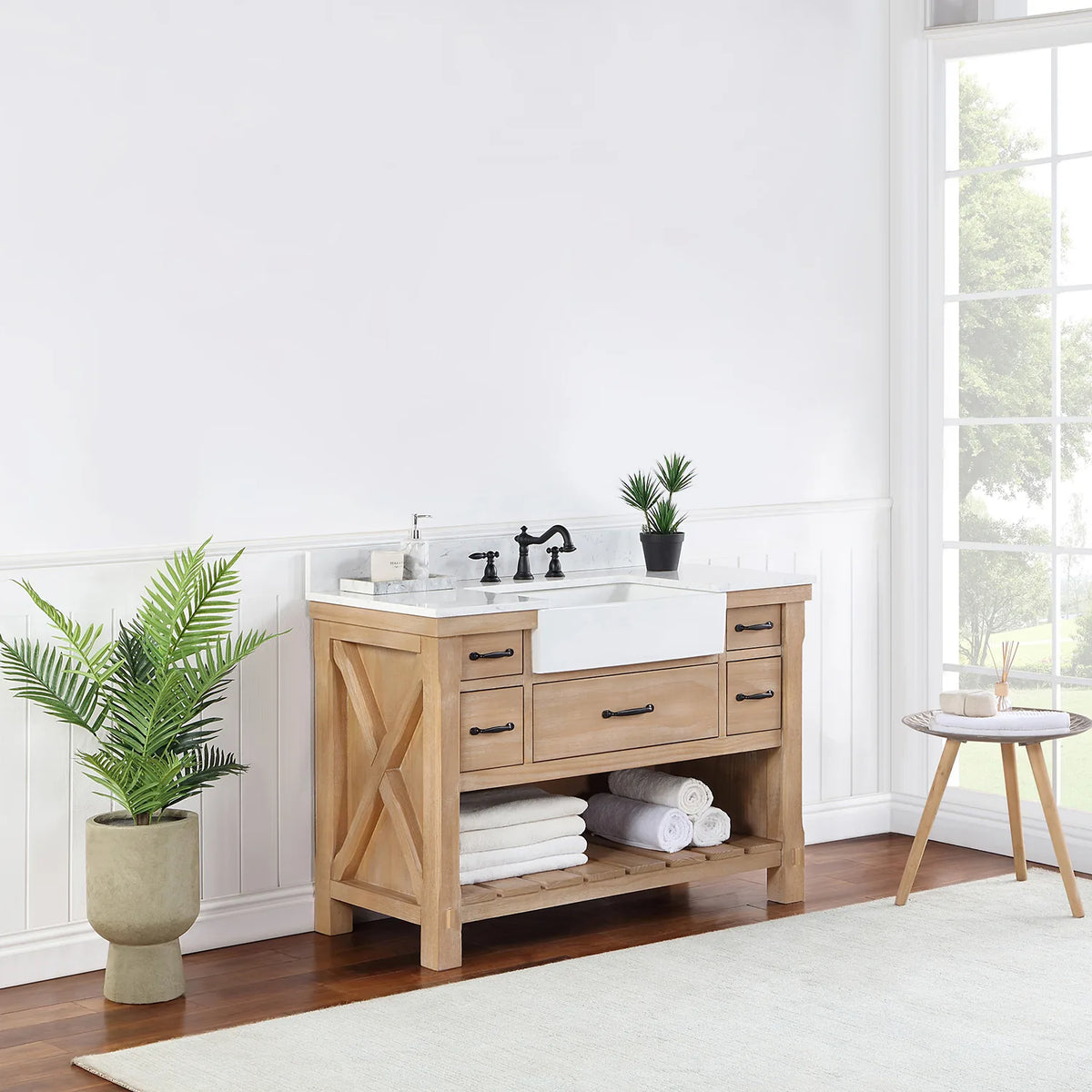 Vanity seen from a distance at an angle, window light and plant beside it