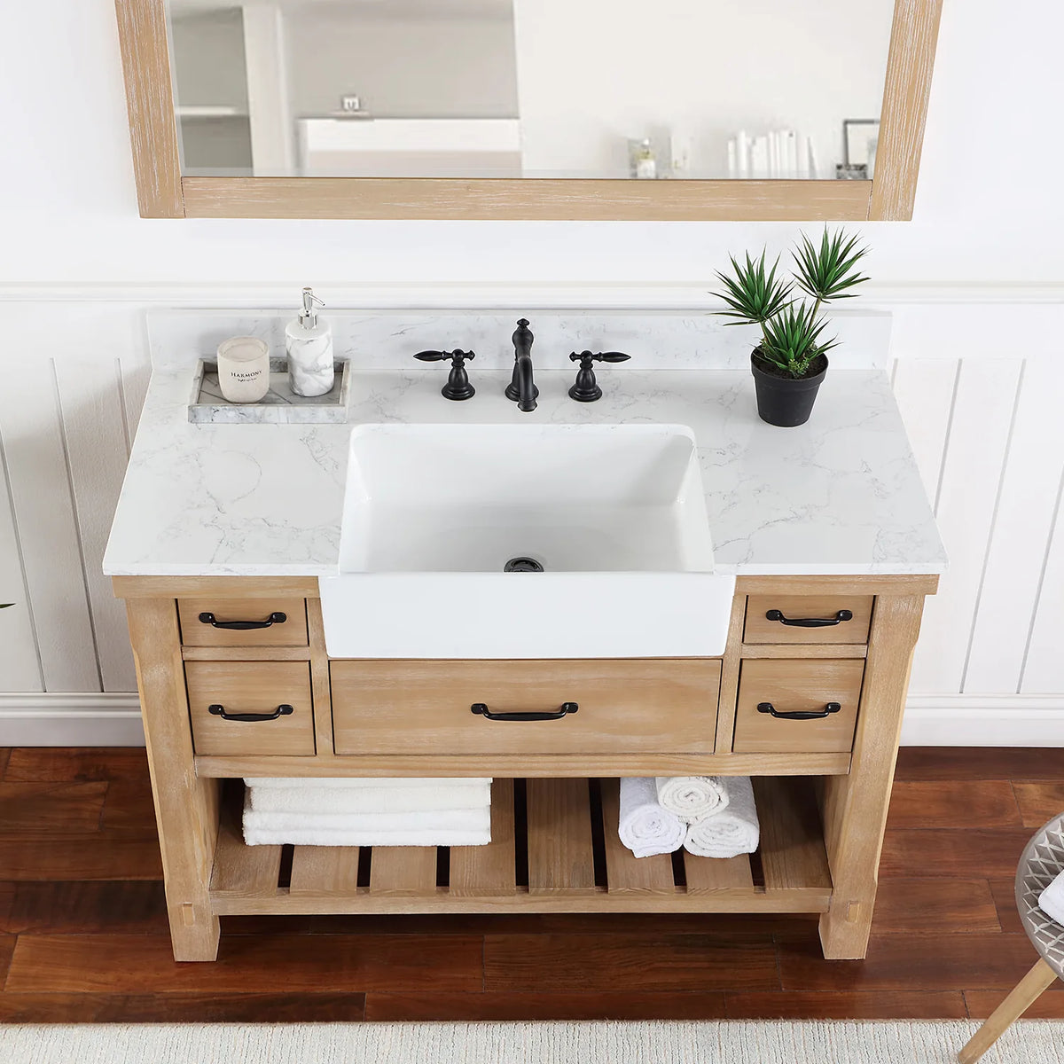 Stone top and white basin in a tighter crop, matte black pulls on the drawer fronts below