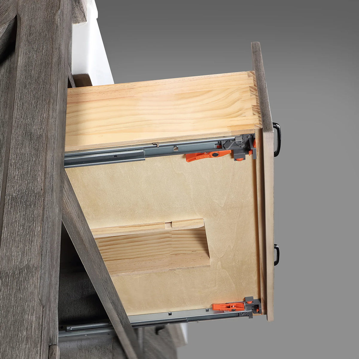 Cutaway of a drawer showing the metal slide and dovetail corner on a grey backdrop
