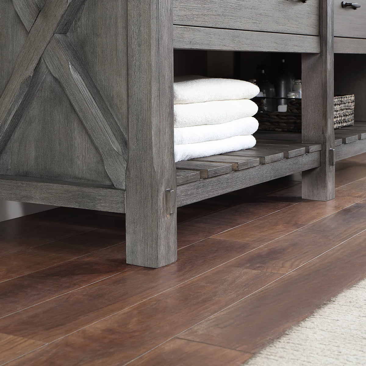 Chunky leg post with X-brace beside the slatted open shelving and rolled towels