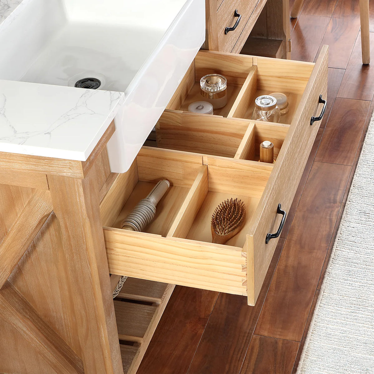 Pulled-forward drawer where jars, bottles and a hairbrush sit in divided compartments