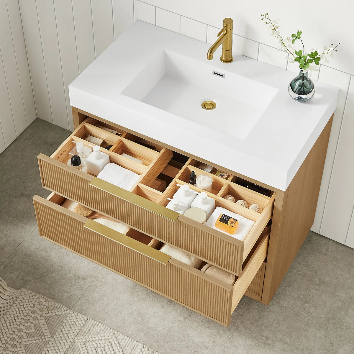 High-angle view of the 36-inch vanity with drawers pulled open to show partition storage, the basin and gold faucet above
