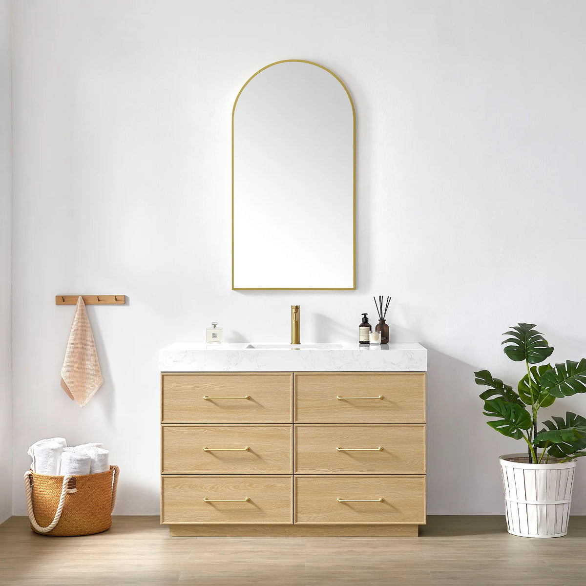 Dark Oak vanity and matching arched mirror with a slim gold frame, styled with towels and a plant