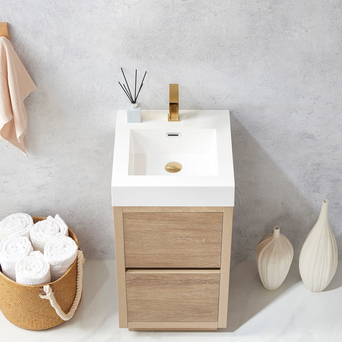Close-up of the white composite integrated sink on the oak vanity, towels rolled in a basket