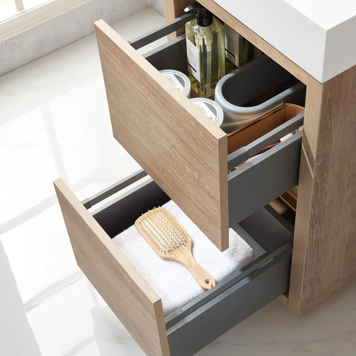 Open drawers on the 18 inch vanity holding toiletries, a towel and a hairbrush