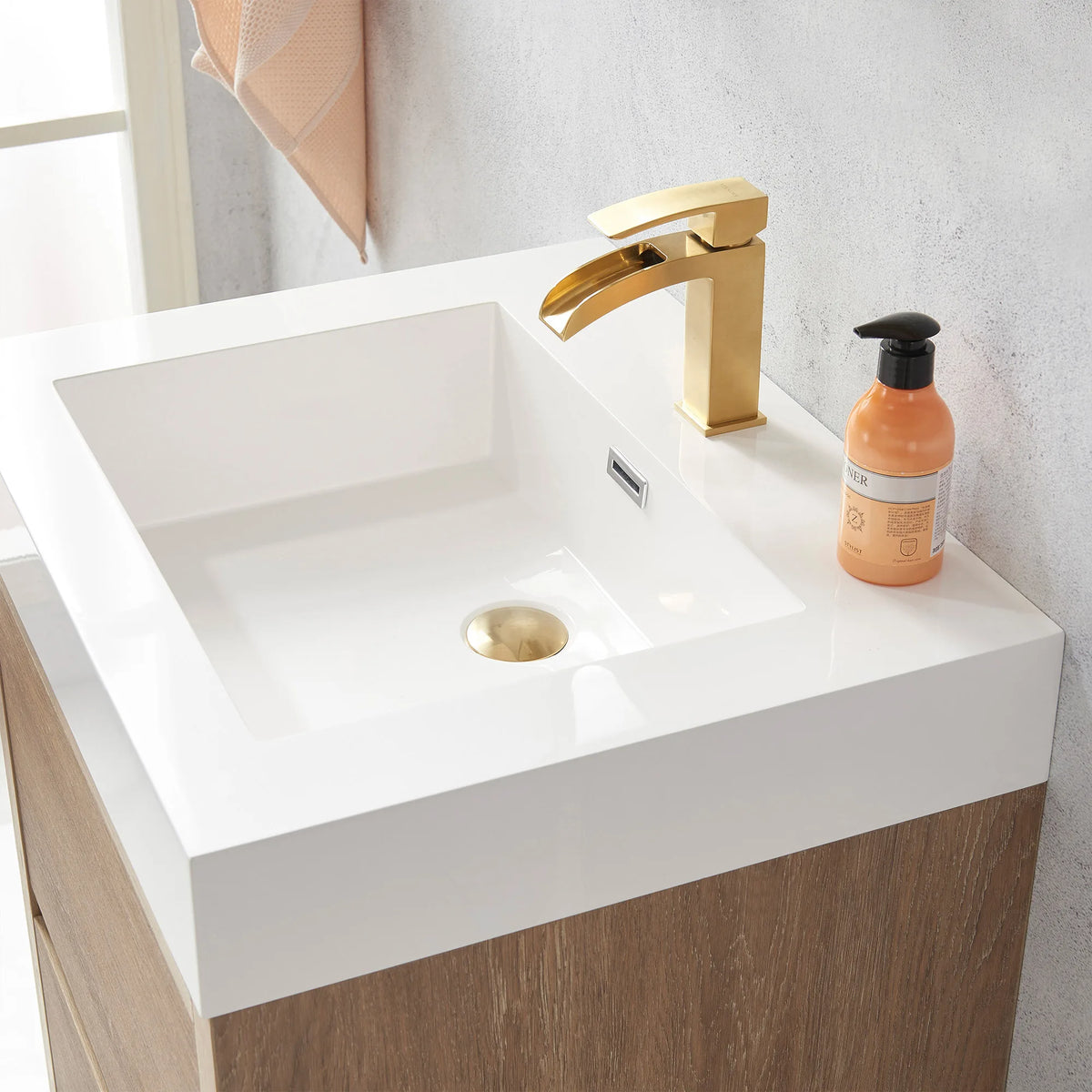 Detail of the integrated white sink with a soap bottle on the 24 inch vanity