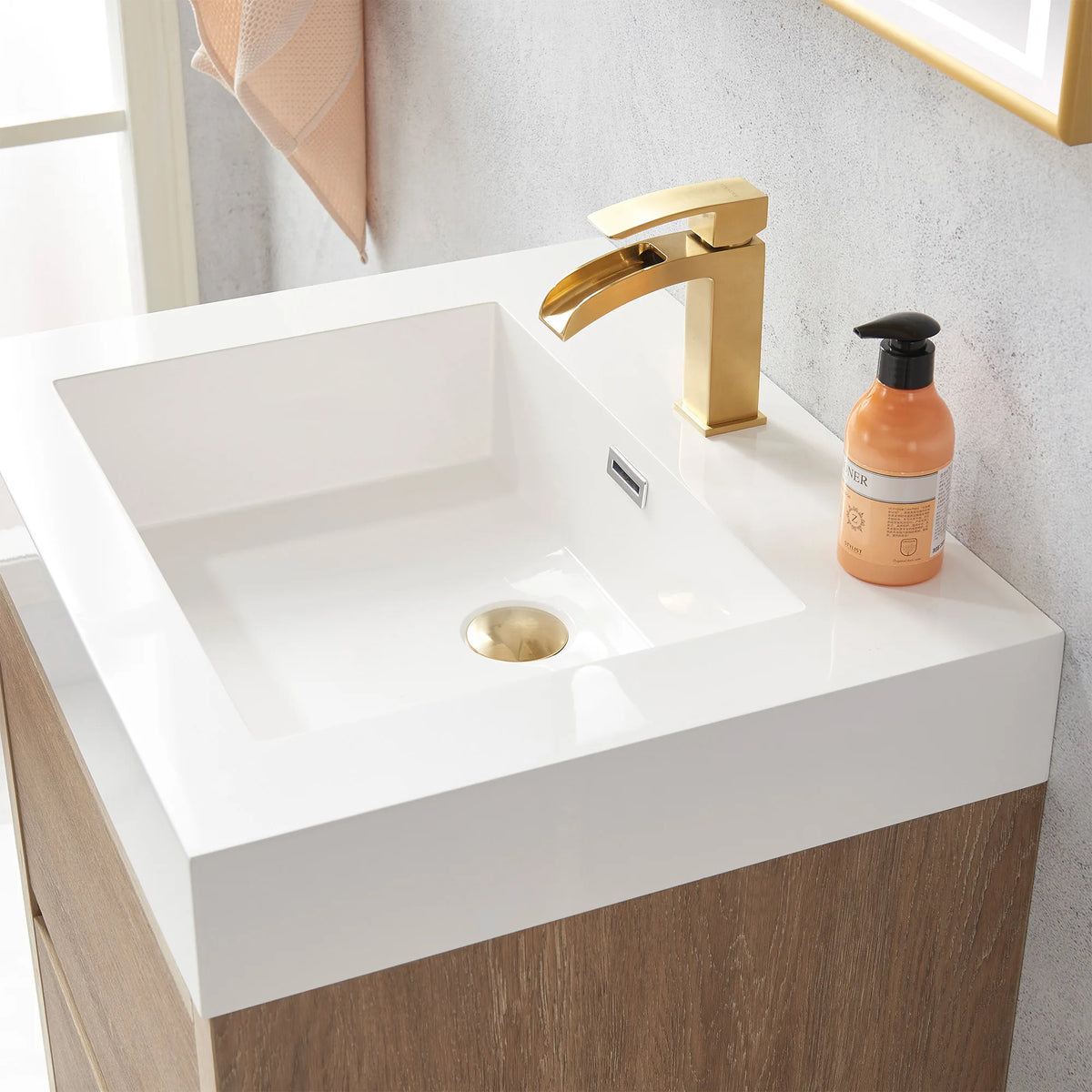 Close-up of the white integrated sink top and drain, soap bottle at the rim