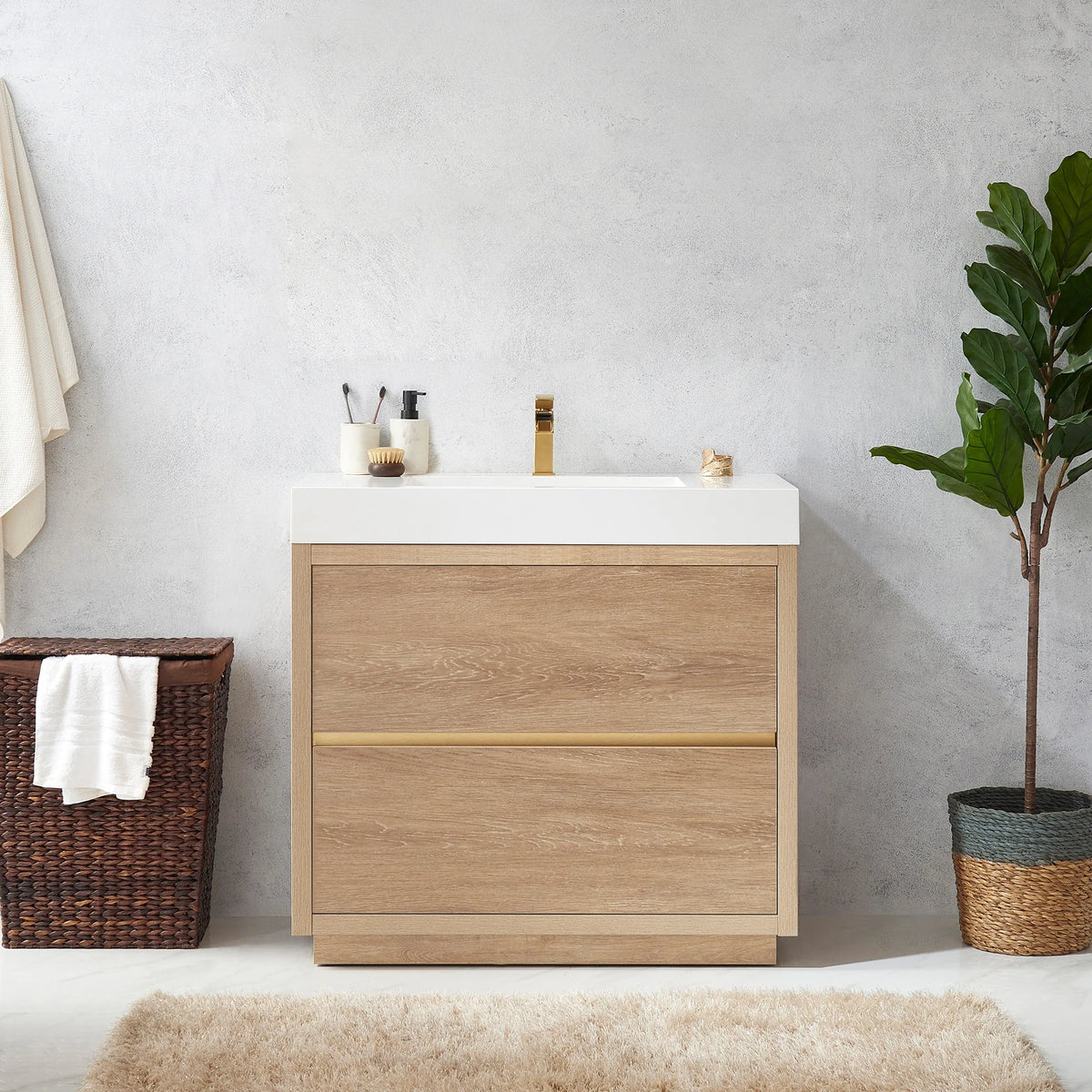 Medium shot of the vanity with toothbrush holder on top, hamper at left, potted plant at right