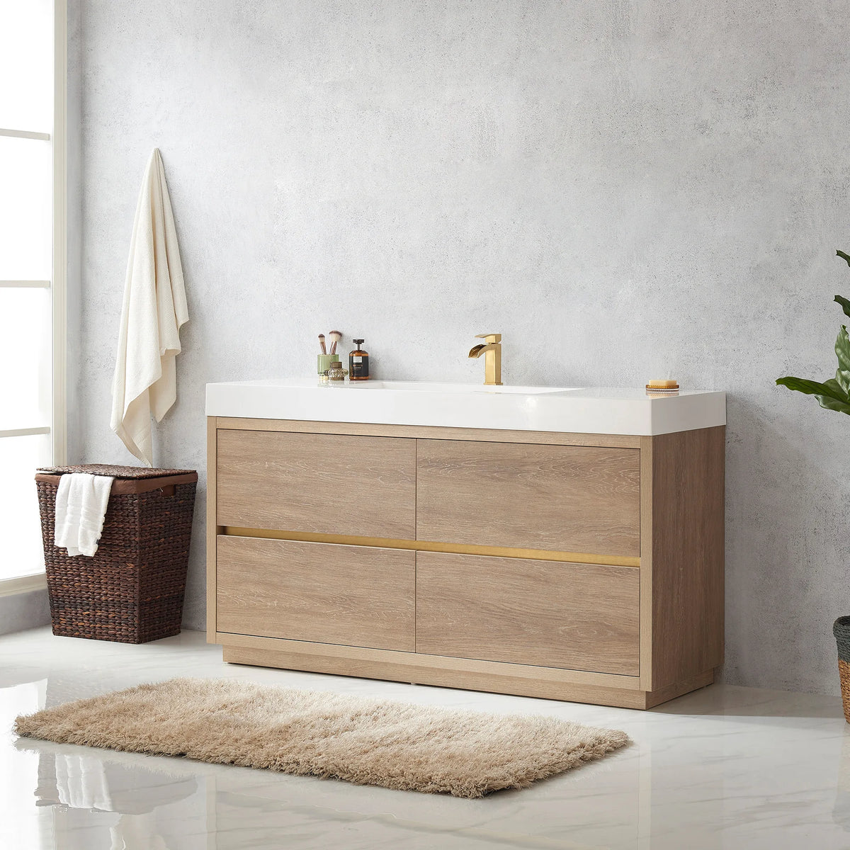 Angled view of the 60 inch vanity with hanging towel, hamper, rug and plant