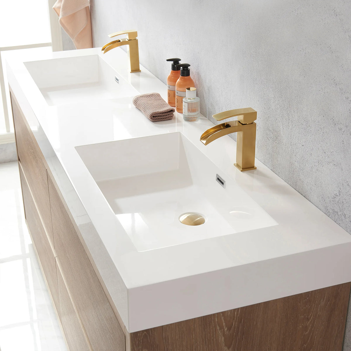 Soap bottles and a rolled towel beside the drain of the double sink top, close view