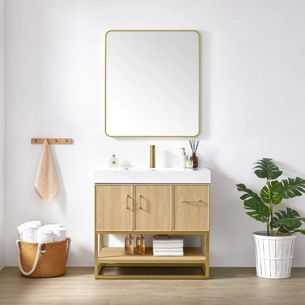 Brushed gold wall mirror above the 36 inch Dark Oak single vanity, with a towel basket and a plant beside it