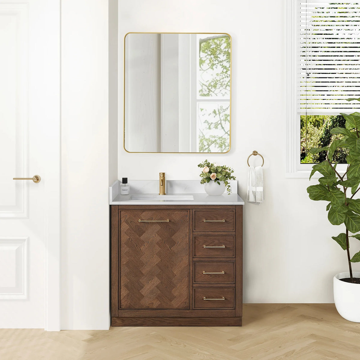 Bathroom scene with the 36-inch single vanity, its matching mirror and a towel ring, plus a tall potted plant by the door