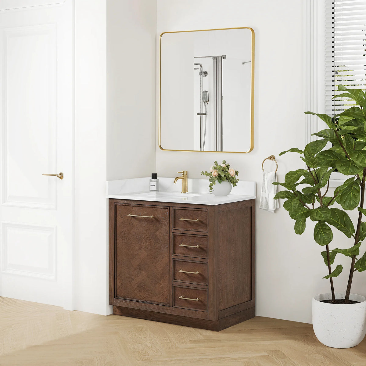 Wide room shot of the 36-inch Aged Dark Brown Oak vanity beneath a gold mirror, with a tall plant and a light wood floor