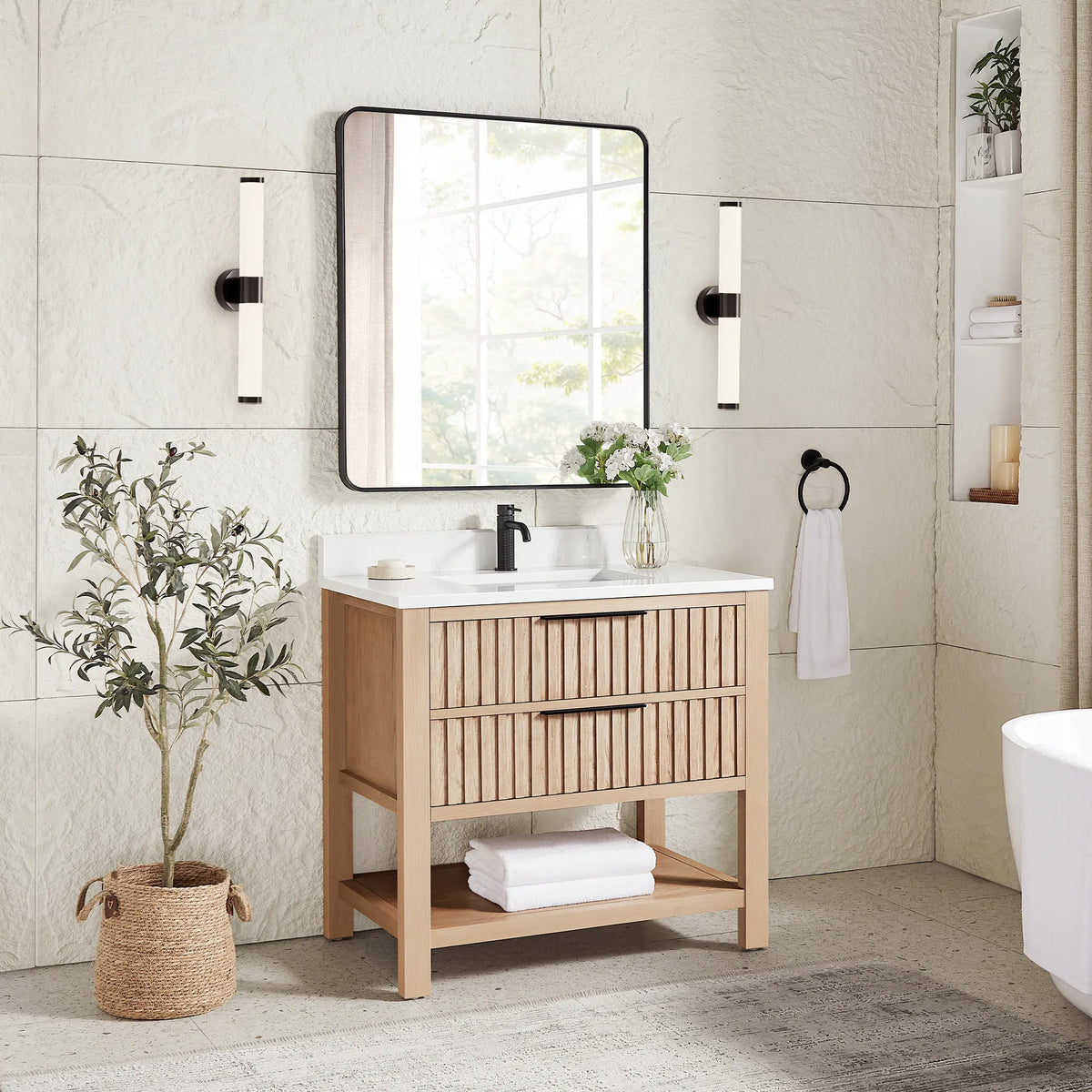 A plant and sconces frame the 36-inch Aged Natural Oak vanity under a matching rectangular mirror in a black frame
