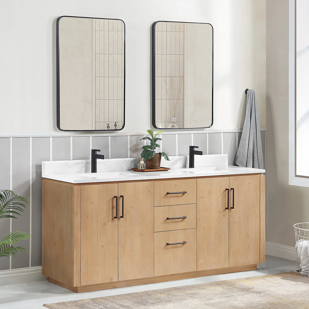 Angled room view of the double vanity with tall mirrors, plant and towel at the right
