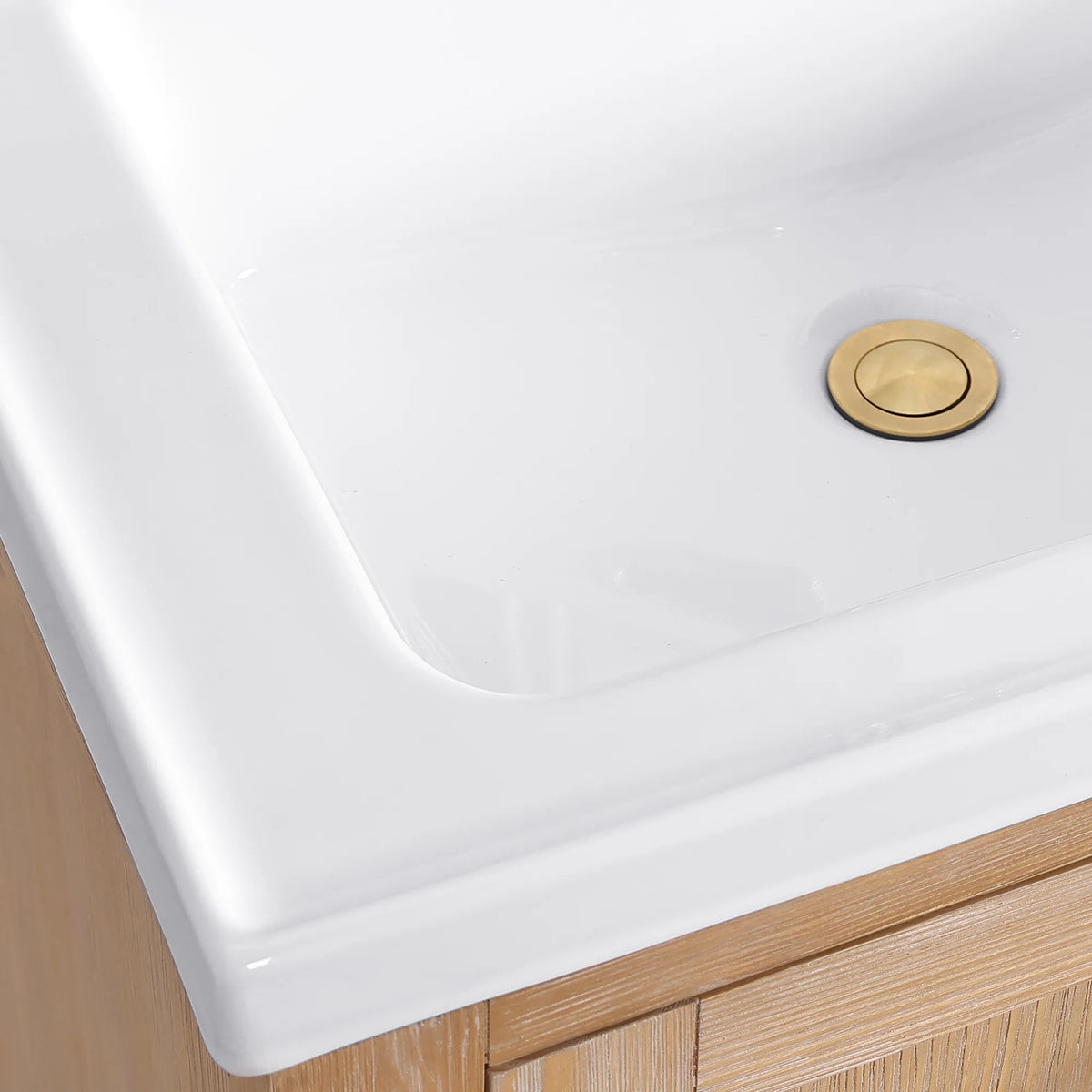 Gold pop-up drain and sloped white rim in a macro view