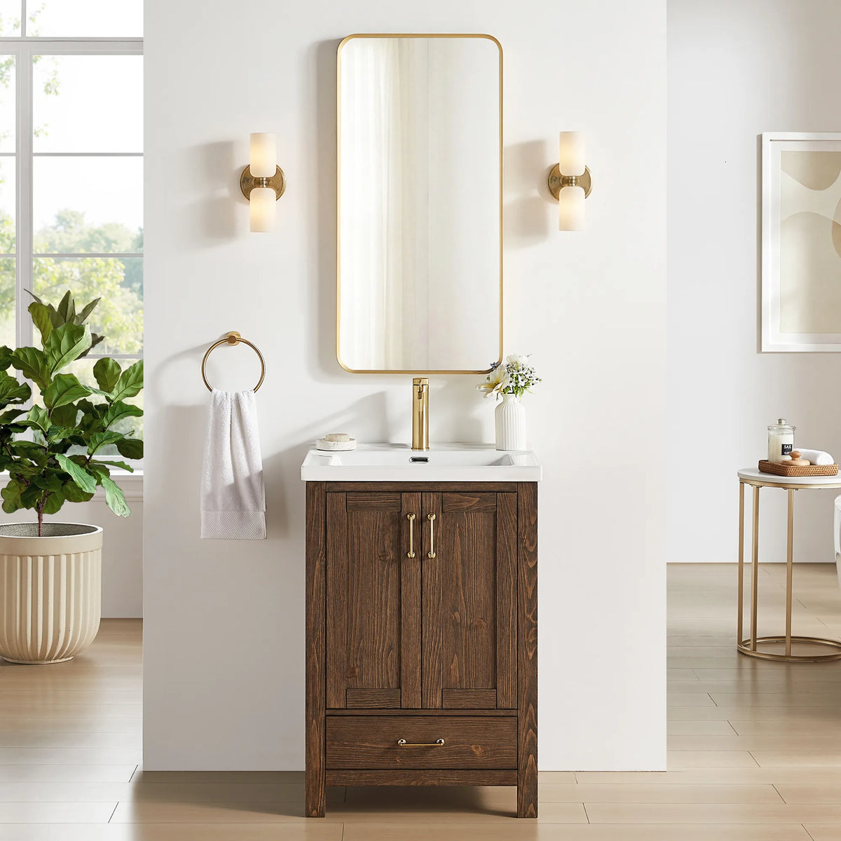 Gold sconces flank a gold-framed mirror above the dark brown vanity