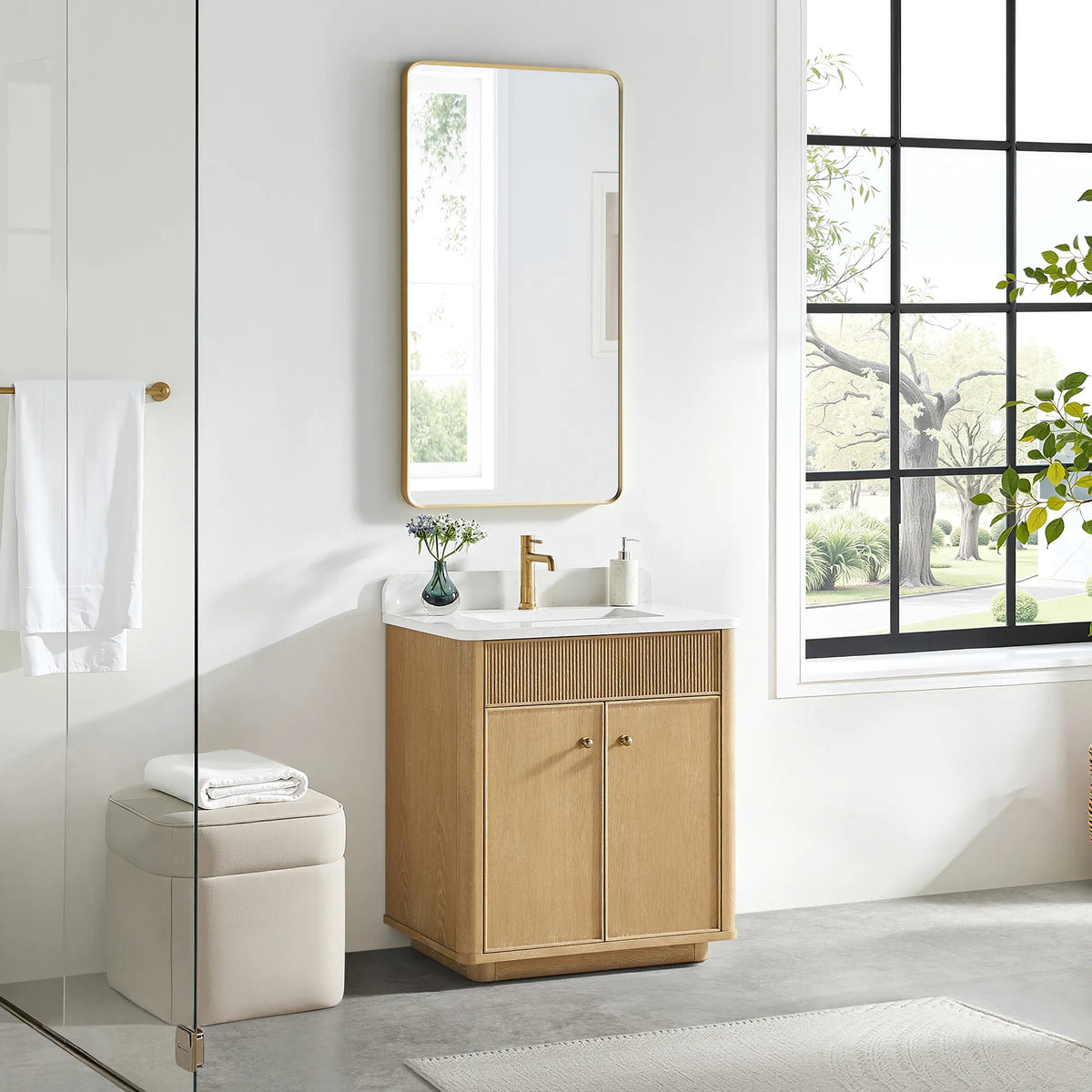30 inch vanity in Washed Ash Grey with a gold-framed mirror above and a cream stool on a gray floor