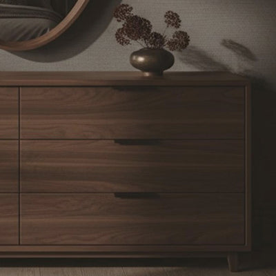 A short video of a wooden dresser with round mirror in a dimly lit room