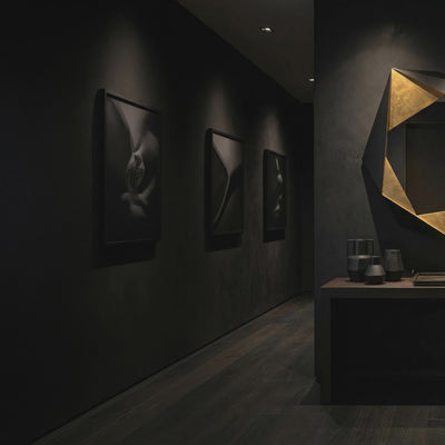 Short product video of Ambella Home Folded Mirror in black and gold, 48W x 5D x 49H geometric wall mirror above a dark credenza in a luxury hallway