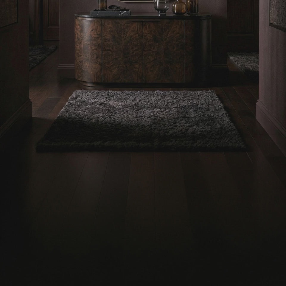 Short product video of the 38 Wavy Mirror - Antiqued Brass by Ambella Home, an elongated tapered wall mirror with a softly scalloped top and antiqued brass frame styled above a dark credenza in a luxury entryway