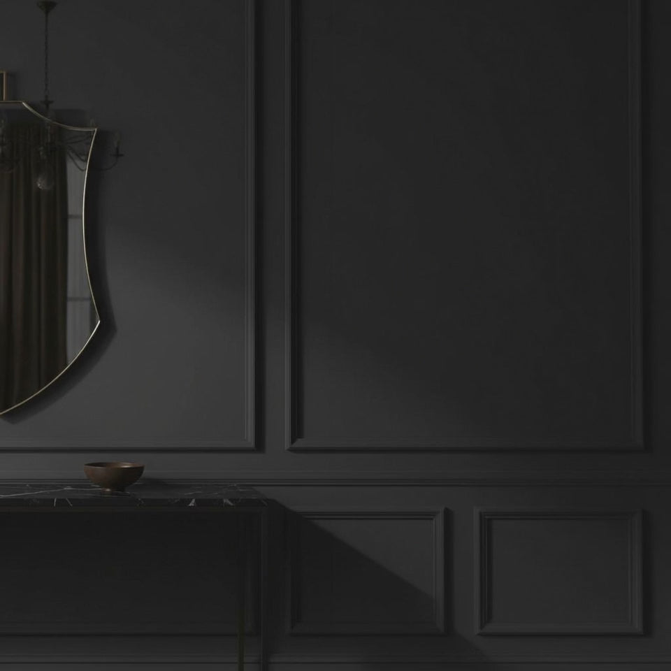 A short video of a decorative mirror on a dark wall with a console table below featuring sculptures and a bowl.