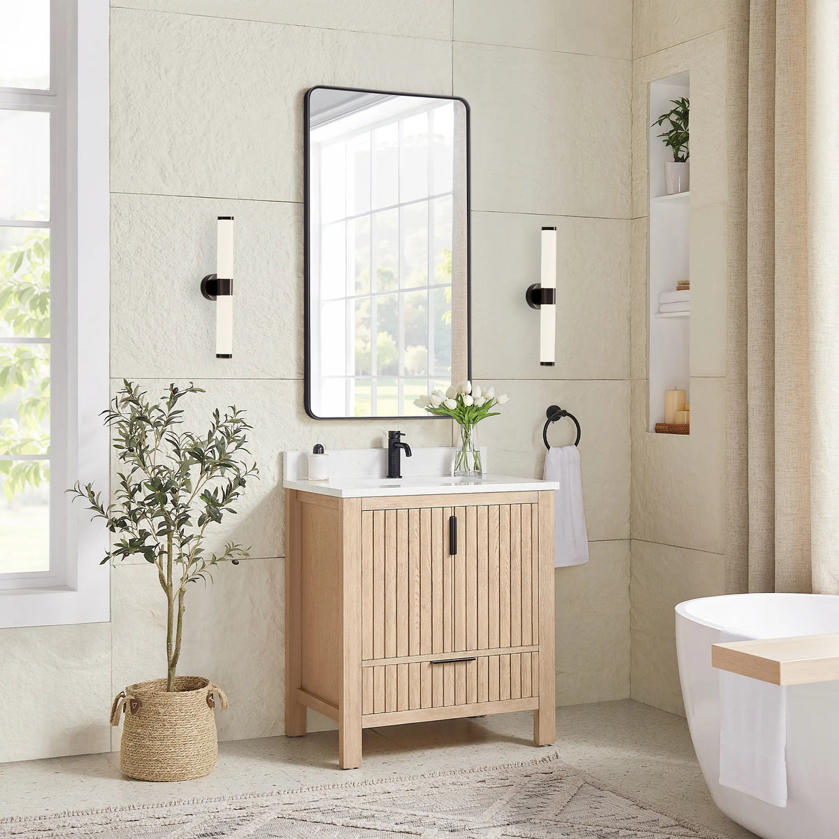 A plant and wall sconces flank the 30-inch Aged Natural Oak vanity under a matching black mirror