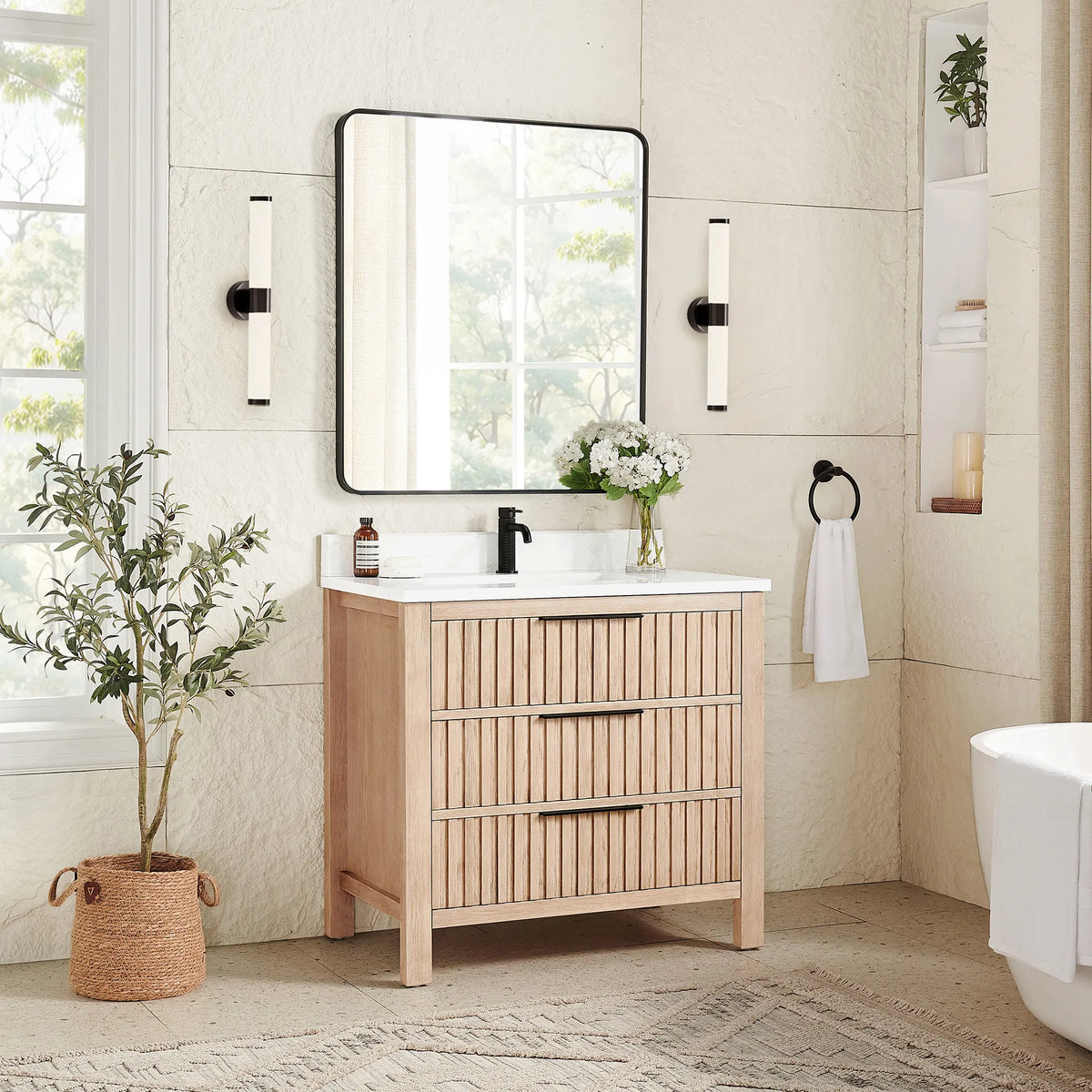 A plant and sconces frame the 36-inch Aged Natural Oak vanity under a matching rectangular mirror in a black frame