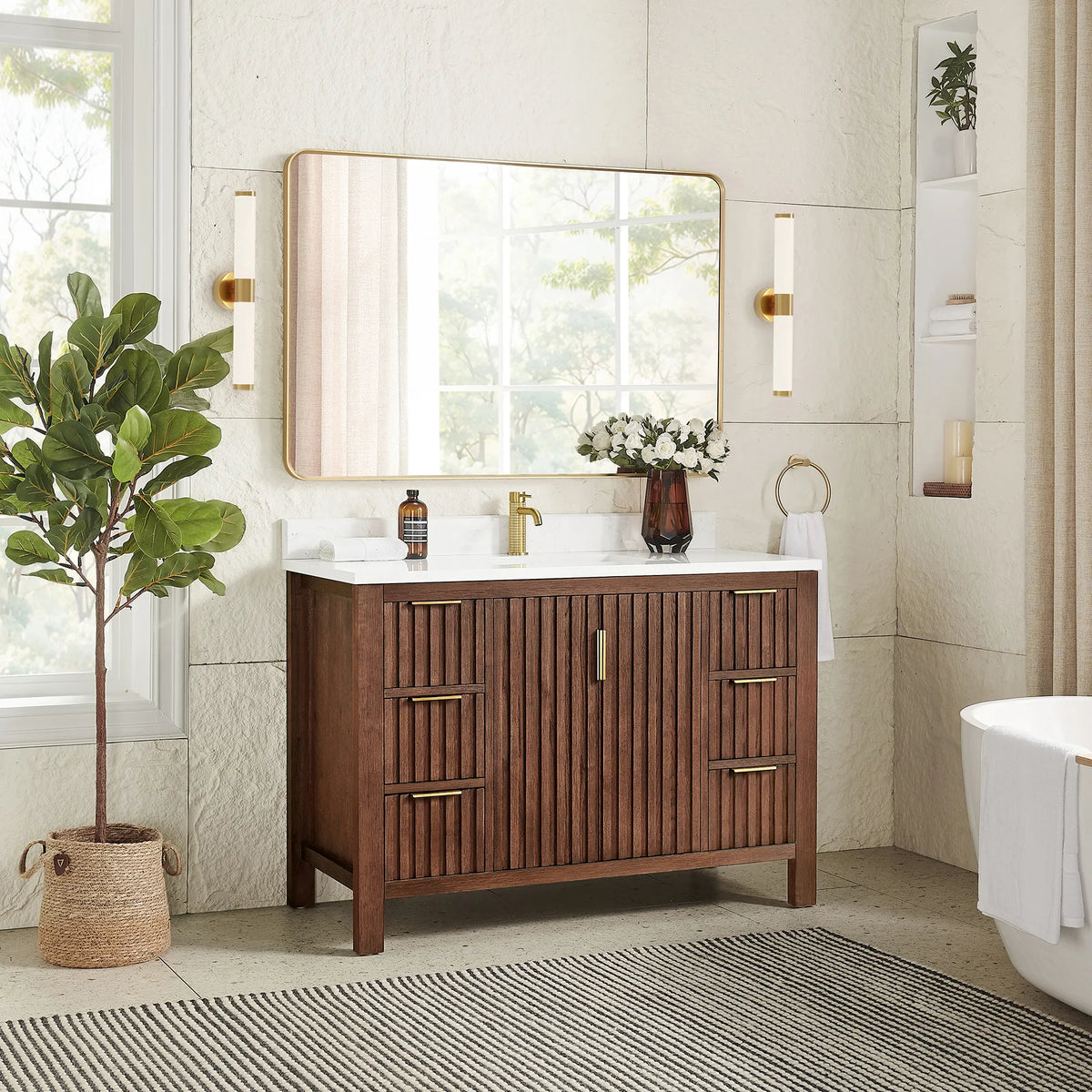 A plant and sconces frame the 48-inch Aged Dark Brown Oak vanity under a matching rectangular mirror in a gold frame