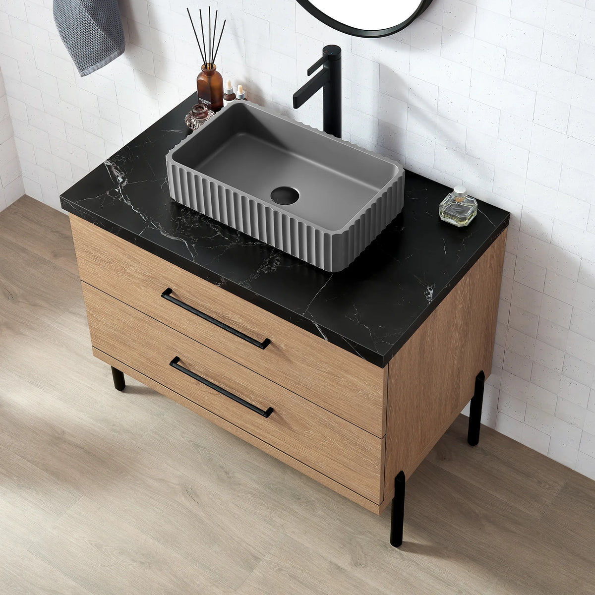 The rectangular ribbed concrete vessel from above, set into marbled black stone