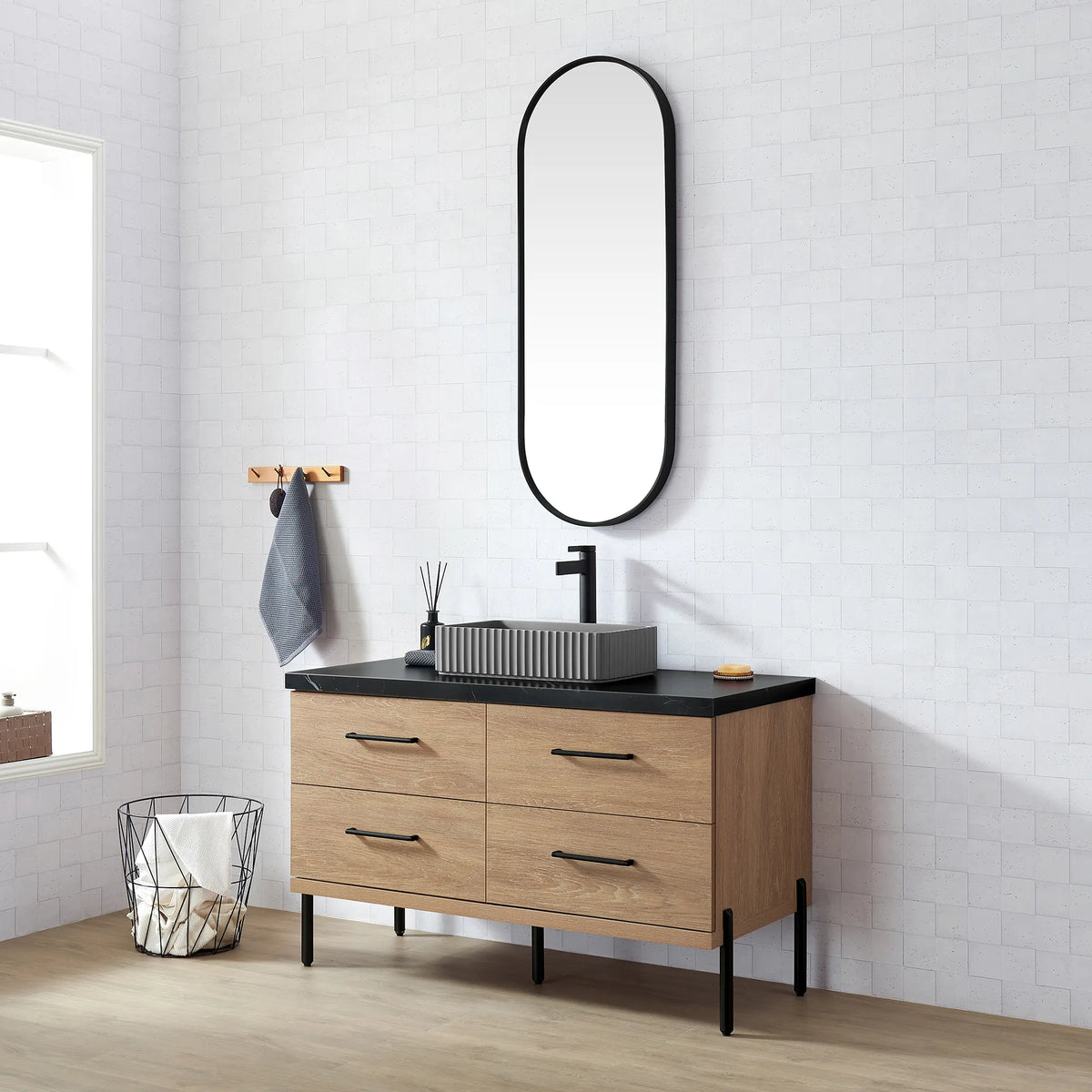 Wire basket on the floor, oak cabinet on black legs, oval mirror above