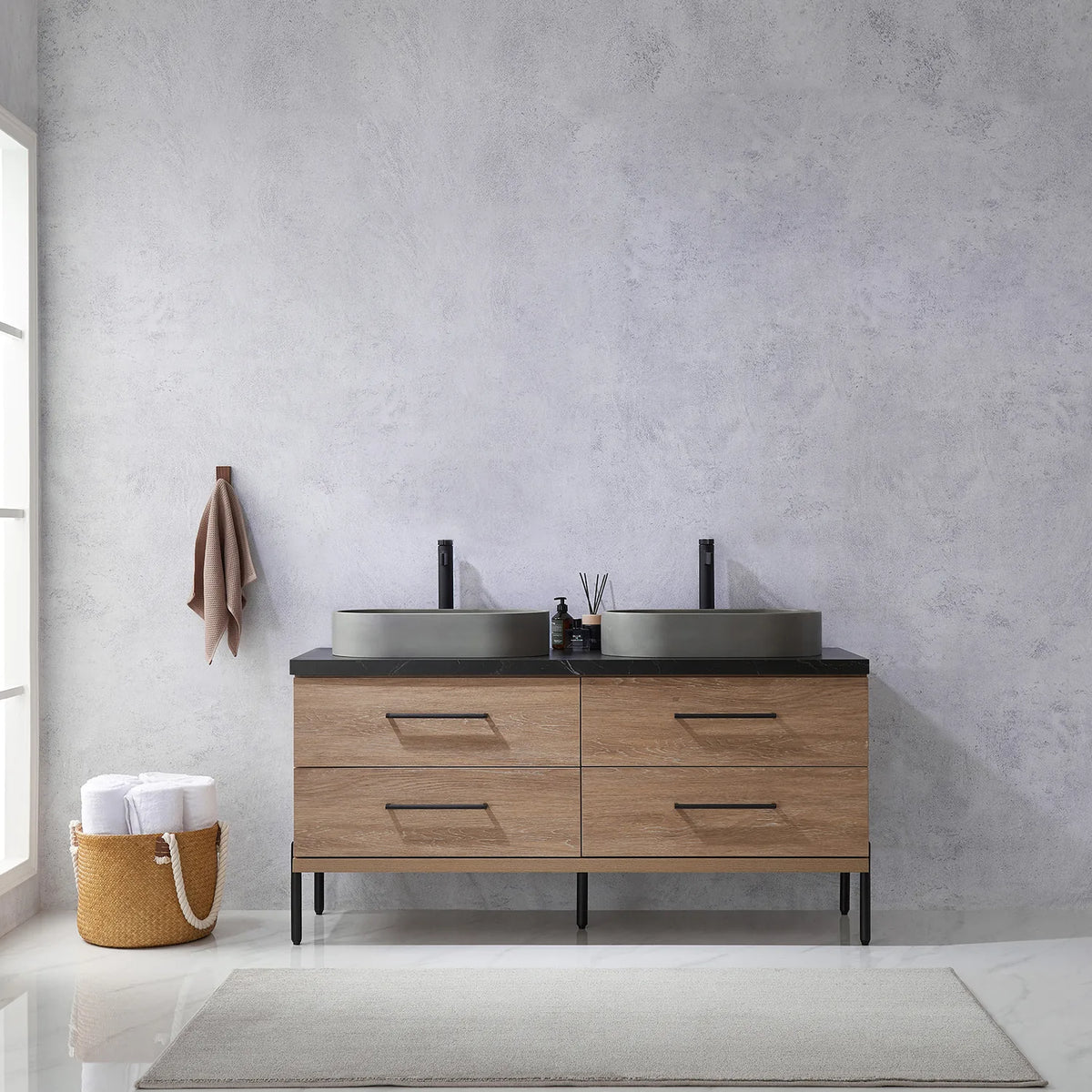 Pale plaster wall, white vases and a hanging towel behind the oak vanity on black legs