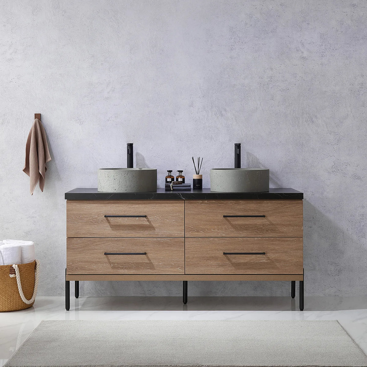 Pale plaster wall, white vases and a hanging towel behind the oak vanity on black legs