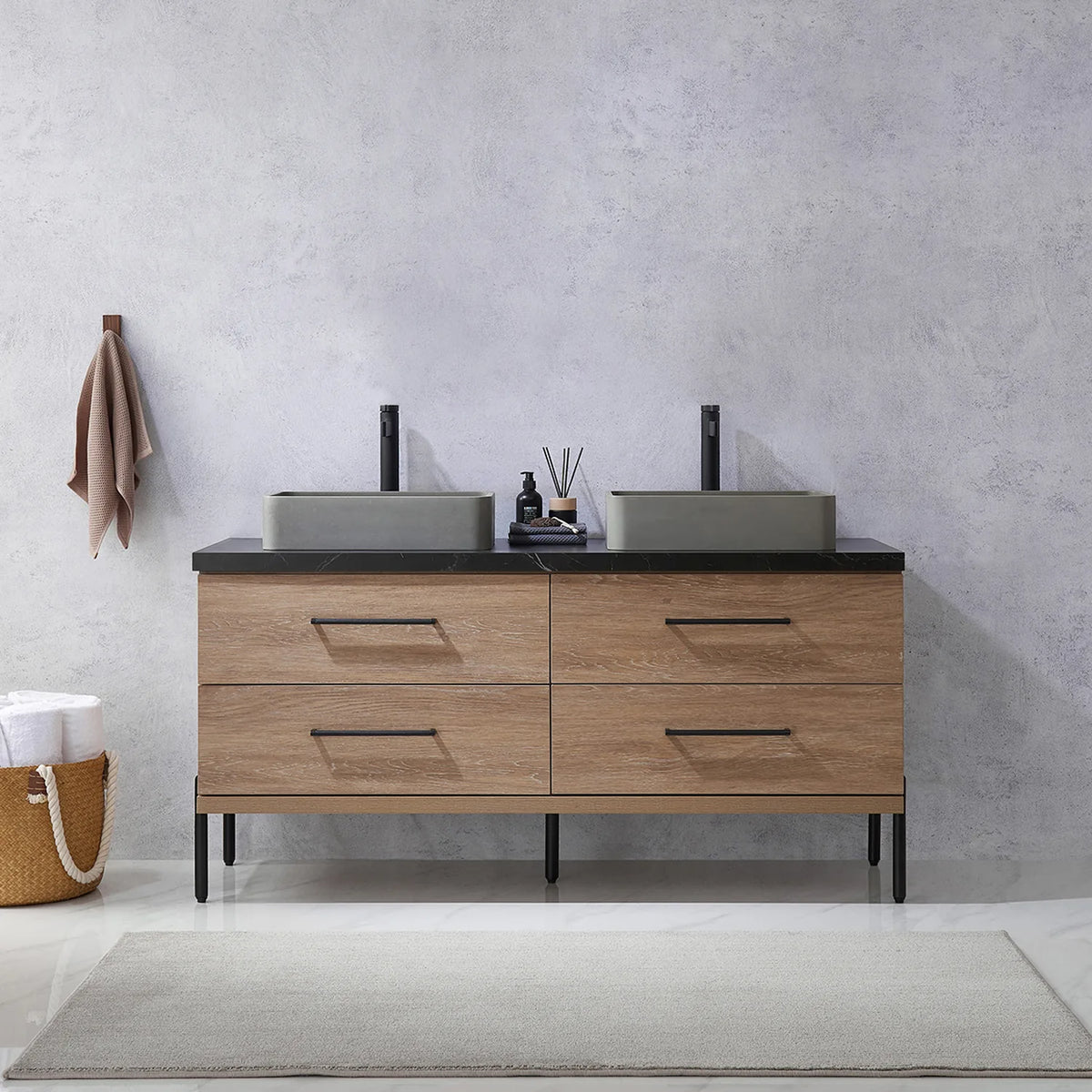 Pale plaster wall, white vases and a hanging towel behind the oak vanity on black legs