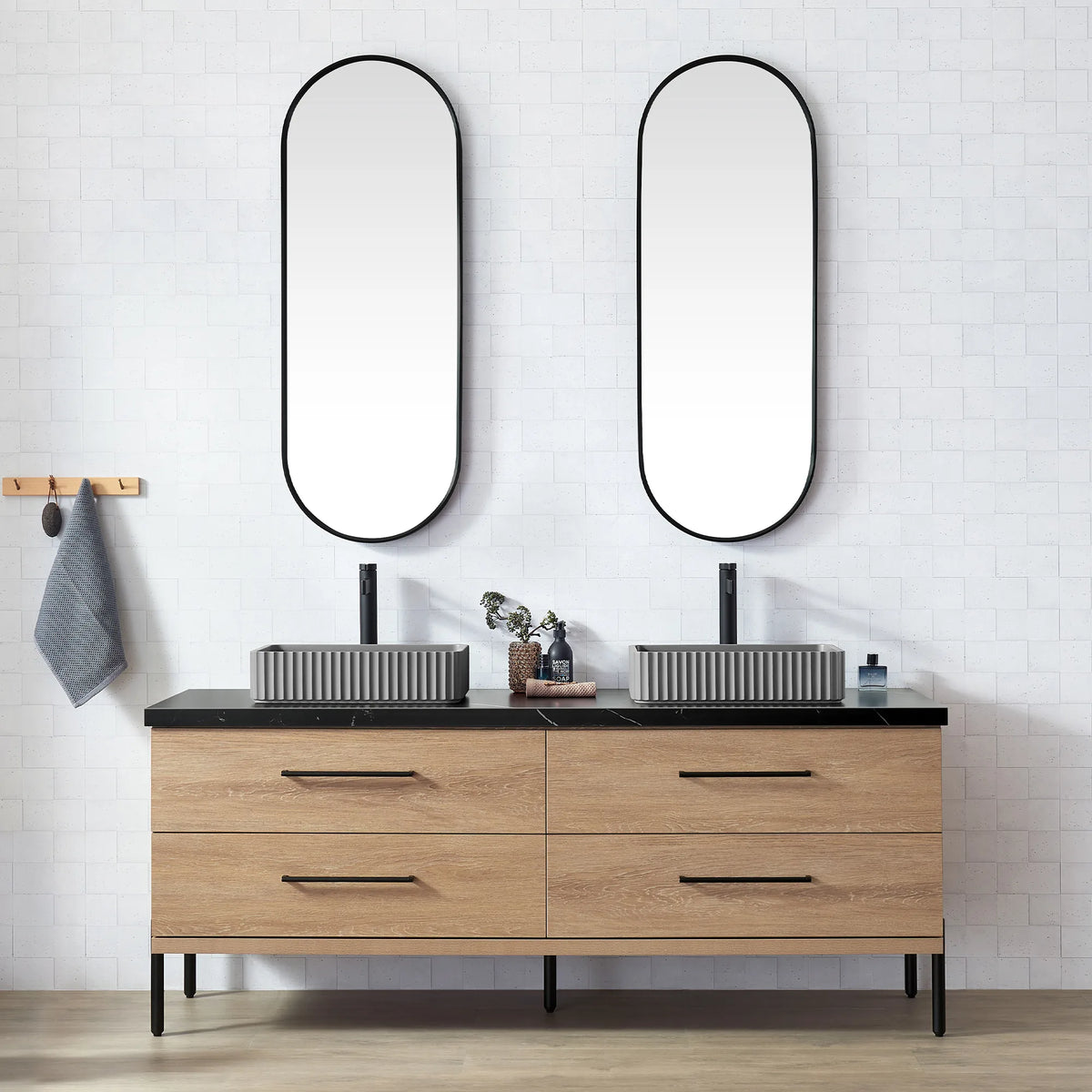 White brick-tile bathroom with oval mirrors and the oak vanity