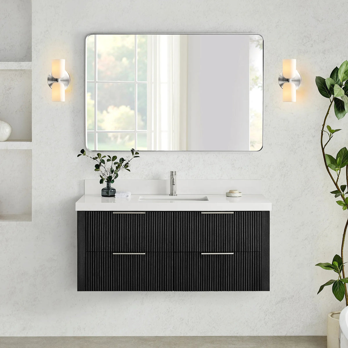 Wall-hung vanity in Oak Weathered Black with a wide rounded-rectangle mirror set between two wall sconces on a textured wall