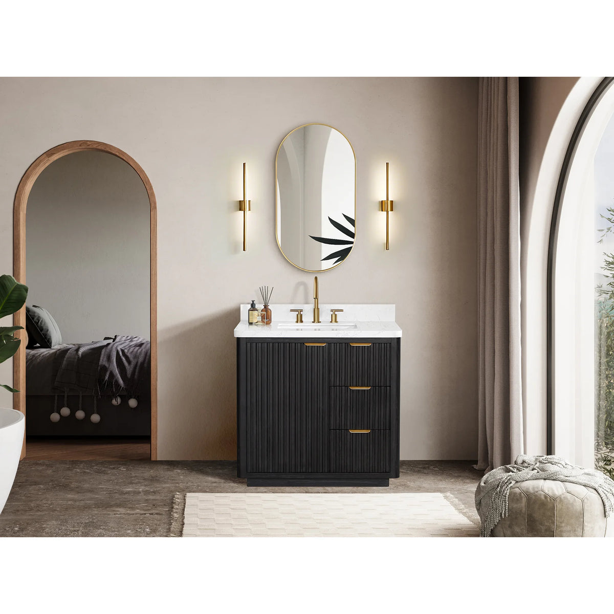 Wide view of the vanity under an oval mirror with arched openings and a pouf beside it